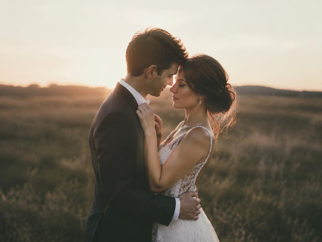 Romantic couple embracing in golden hour wildflower meadow